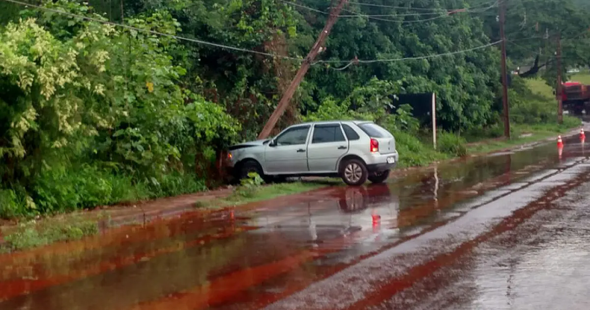 Carro derrapa em pista molhada e colide em poste de energia